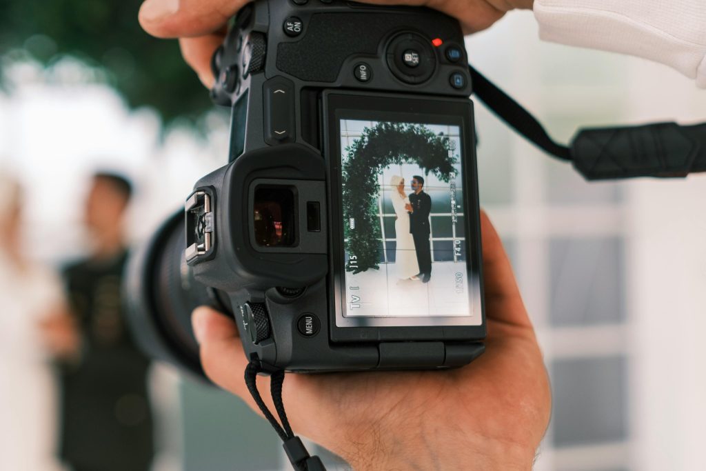 Lens of photographer, wedding couple in frame